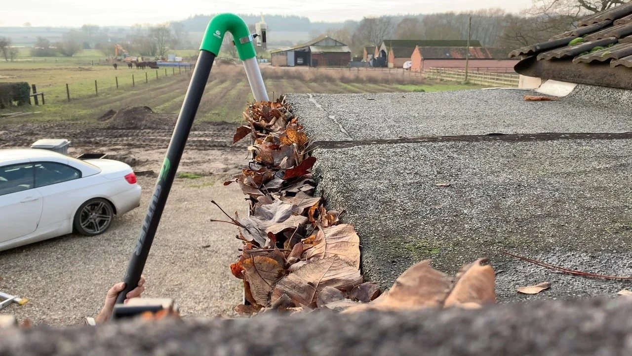 Gutter vacuum clearing leaves from blocked gutters
